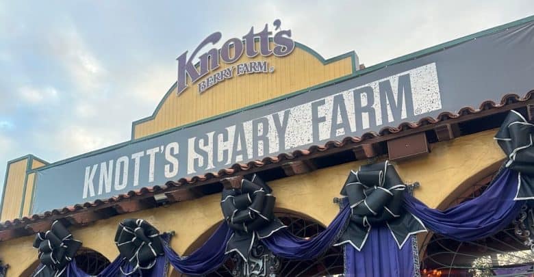 The entrance to Knott’s Berry Farm decorated for Halloween with a sign reading “Knott’s Scary Farm,” black bows, and dark purple drapes.