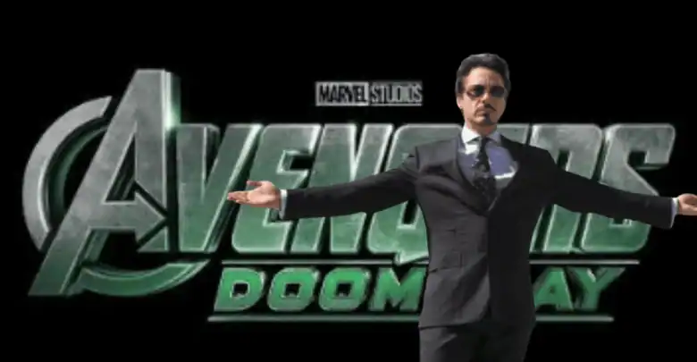 A man in a suit stands with arms wide open in front of a large "Avengers: Doomsday" logo with the Marvel Studios label above it, set against a plain black background.