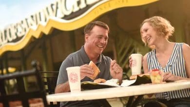 A man and woman sat eating outside Earl of Sandwich in Disney Springs
