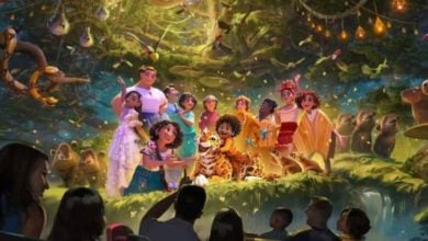An animated group of colorful characters poses in a magical forest with glowing lights, animals, and birds, watched by silhouetted people in the foreground as if on a ride or attraction.