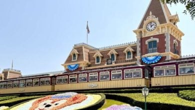 The Disneyland Train Station’s clock tower, bunting, and floral Mickey face—an iconic welcome for Disney Annual Passholders.