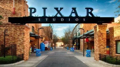Pixar Studios’ iconic entrance gate and brick buildings shine under sunny skies, teasing fans for the June 2027 movie launch.