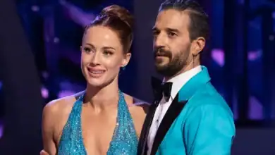 A glamorous woman in a sparkly blue dress poses with a man in a turquoise suit at Disney Studios, bringing DWTS flair to the park.