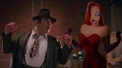 A guest in a suit reacts with surprise beside Jessica Rabbit posing in her signature red dress and gloves at a Disney park.