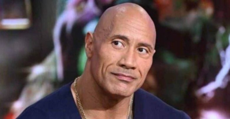 A Dwayne Johnson lookalike with a neutral gaze glances aside, set before an out-of-focus backdrop, ready for the franchise ride.