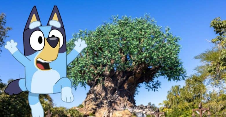 Bluey leaps playfully before a grand tree in Australia Land’s Animal Kingdom, set against blue skies and vibrant greenery.