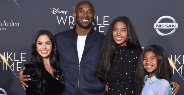 A cheerful family of four gathers for a photo on the red carpet at a Disney premiere, surrounded by festive movie-themed decorations and excited fans.