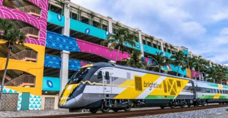 A Brightline train glides past colorful murals and swaying palm trees under the sun, kicking off Disney visitors’ adventure with a vibrant cityscape before they reach the magic.