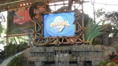 Universal Orlando logo on a screen framed by bamboo, above a stone water feature at the site of a closed attraction.