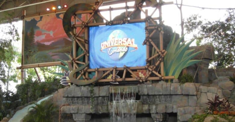 Universal Orlando logo on a screen framed by bamboo, above a stone water feature at the site of a closed attraction.