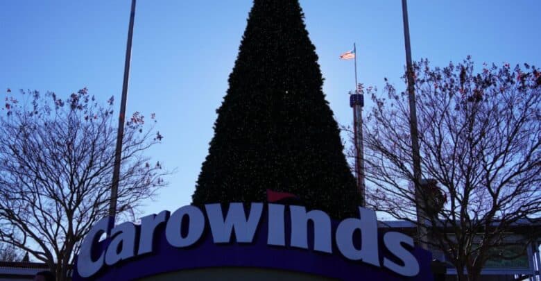 A large Christmas tree stands behind the Carowinds entrance sign during the park’s attraction closures.