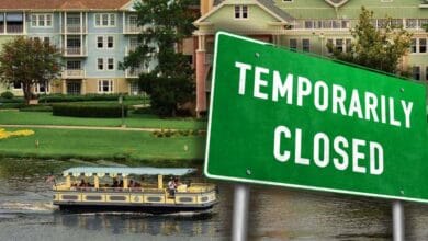 A green Temporarily Closed sign in front of a Disney’s Old Key West Resort lake with a Friendship boat.