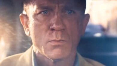 James Bond driving with a serious expression.