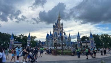 Cinderella Castle at Magic Kingdom under a cloudy sky, accessible via Lightning Lane.