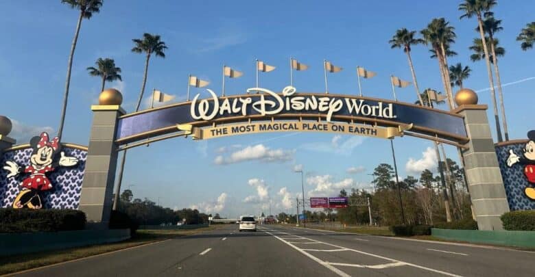 Walt Disney World entrance archway featuring Mickey and Minnie Mouse icons illuminated by flashing lights.