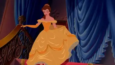 Belle descending the staircase in her iconic yellow ball gown at a Disney park.