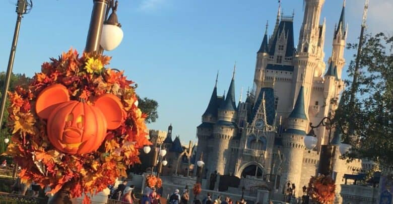 A Mickey Mouse pumpkin wreath hangs in front of Cinderella Castle for Magic Kingdom news.