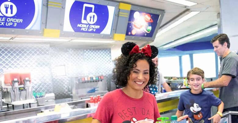A guest wearing Minnie ears at Cosmic Ray’s Starlight Cafe in Magic Kingdom, featuring food policy information.