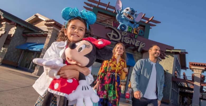 A child holds a Minnie Mouse plush in front of World of Disney at Disney Springs.