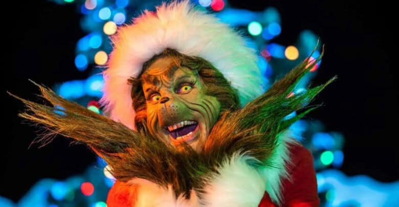 The Grinch in a Santa hat during Universal holiday travel.
