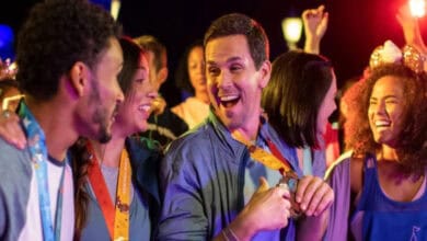 Group of runners celebrating at Disney World while wearing runDisney medals and Mickey ears.