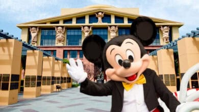Mickey Mouse waving in front of the Team Disney Building at Disney World.
