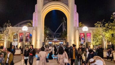 Crowd entering the Universal Studios Japan entrance at night.