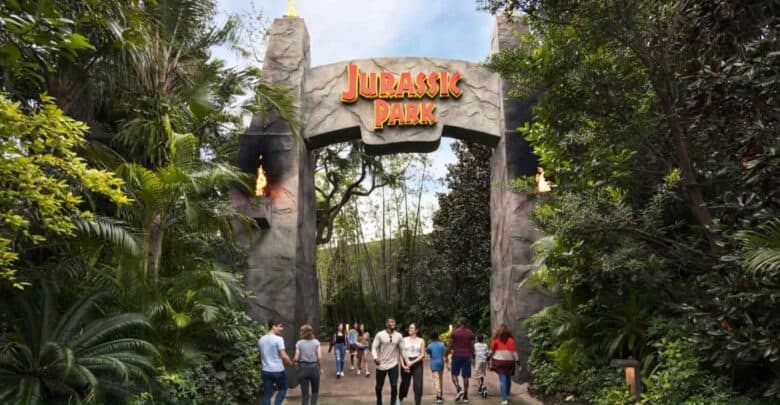 Guests pass through the Jurassic Park gates at Universal Studios, which are currently closed for River Adventure.