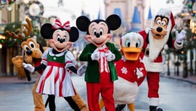 Mickey, Minnie, Donald, Goofy, and Pluto in holiday outfits on Main Street, U.S.A. during Christmas at Magic Kingdom.