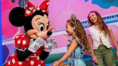 Minnie Mouse meeting a young girl and her mother at Disney World.