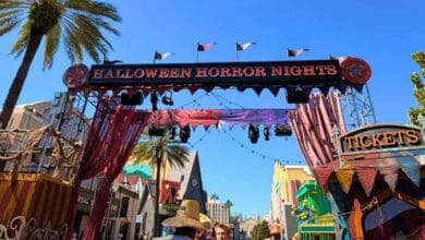 Halloween Horror Nights entrance archway at Universal Studios featuring a park rules broadcast warning.