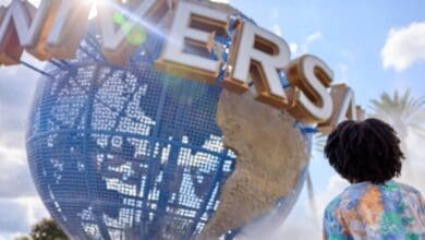 A visitor looks up at the spinning Universal globe during Holidays at Universal Orlando.