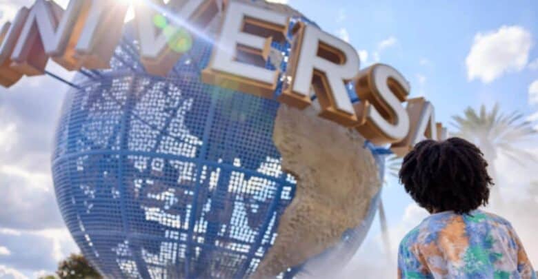 A visitor looks up at the spinning Universal globe during Holidays at Universal Orlando.